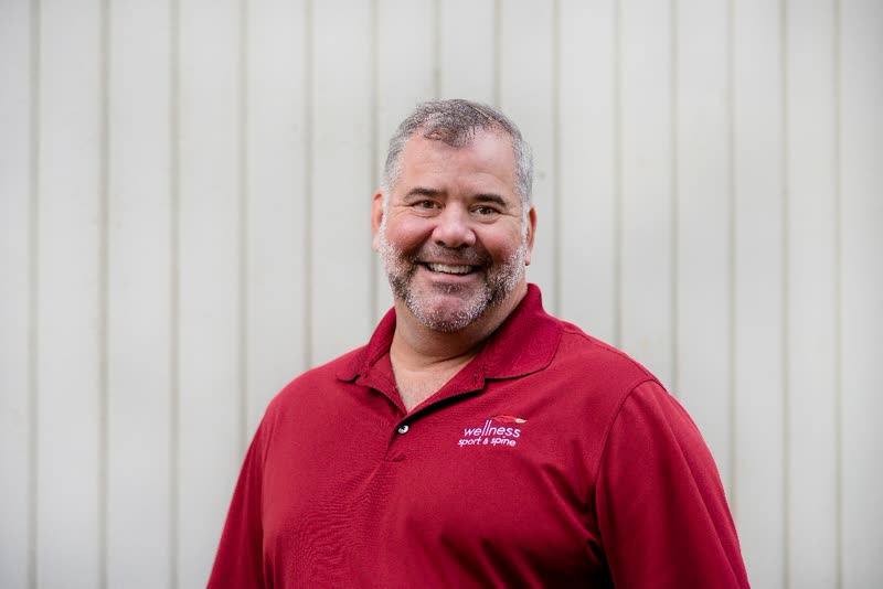 Headshot of Dr. Brian Farrell wearing a Wellness Sport & Spine polo