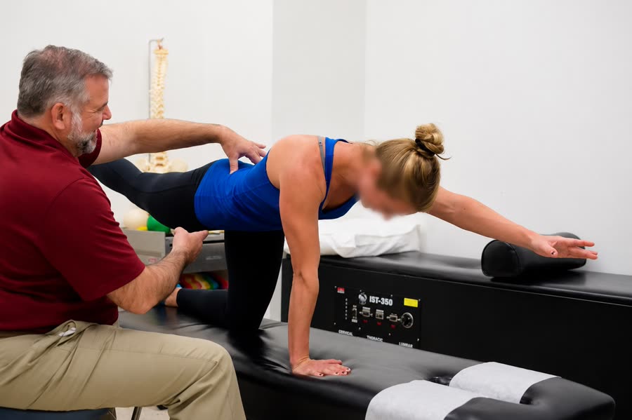 Dr. Farrell guiding an athlete through a stretching and rehab exercise