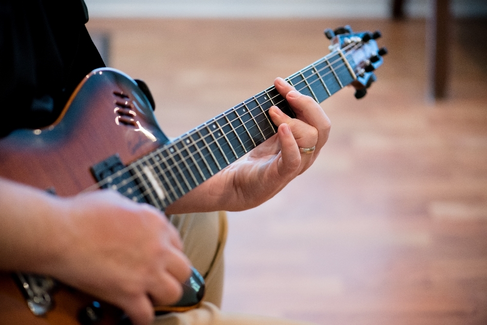 Someone sitting playing the guitar